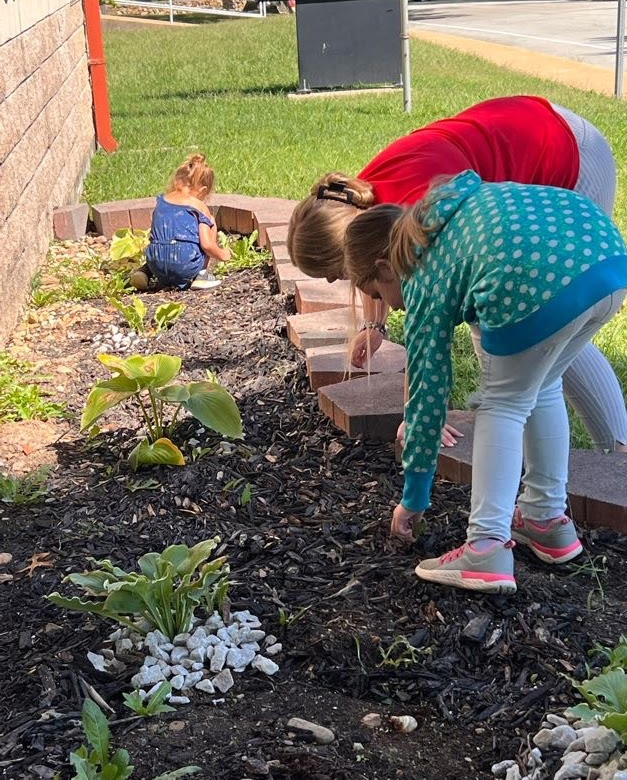 Elementary students pull weeds